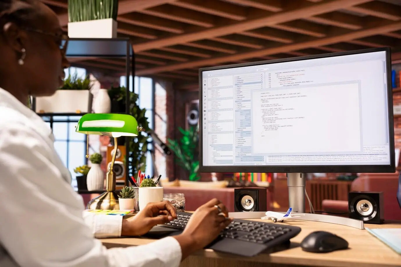 Systemadministrator im Büro einer Wohnung tippt Code in den PC und entwickelt Software.