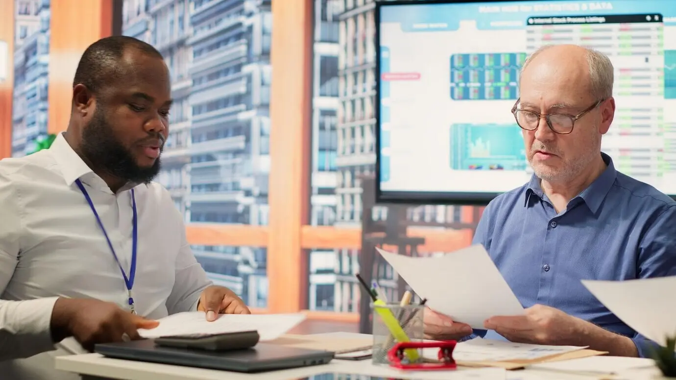 Ältere Menschen diskutieren mit einem Finanzexperten über passende Ruhestandspläne.